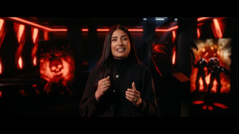 Asha Sharma speaking during a red-lit Xbox Games Showcase segment for Gears of War: E-Day