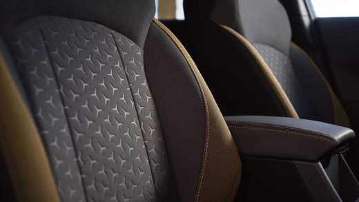 Close-up of patterned cloth front seats and center armrest in a Subaru Crosstrek interior.