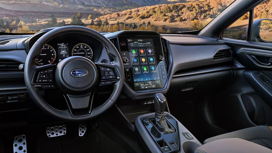 Subaru Crosstrek Hybrid dashboard and steering wheel with a large center touchscreen and mountain scenery ahead.